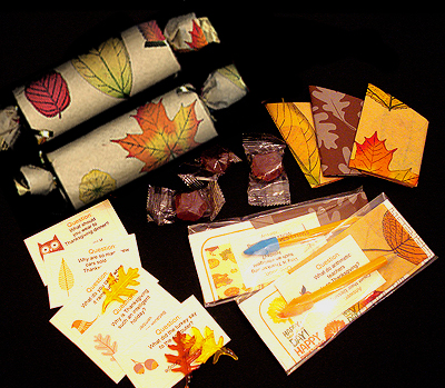 Thanskgiving crackers decorated with fall coloured leaves.  Holiday Crackers with paper hats, maple candy, puzzles and jokes.